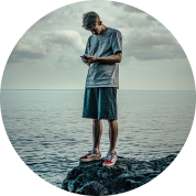 image of a man struggling with a mental health condition on a rock near the beach