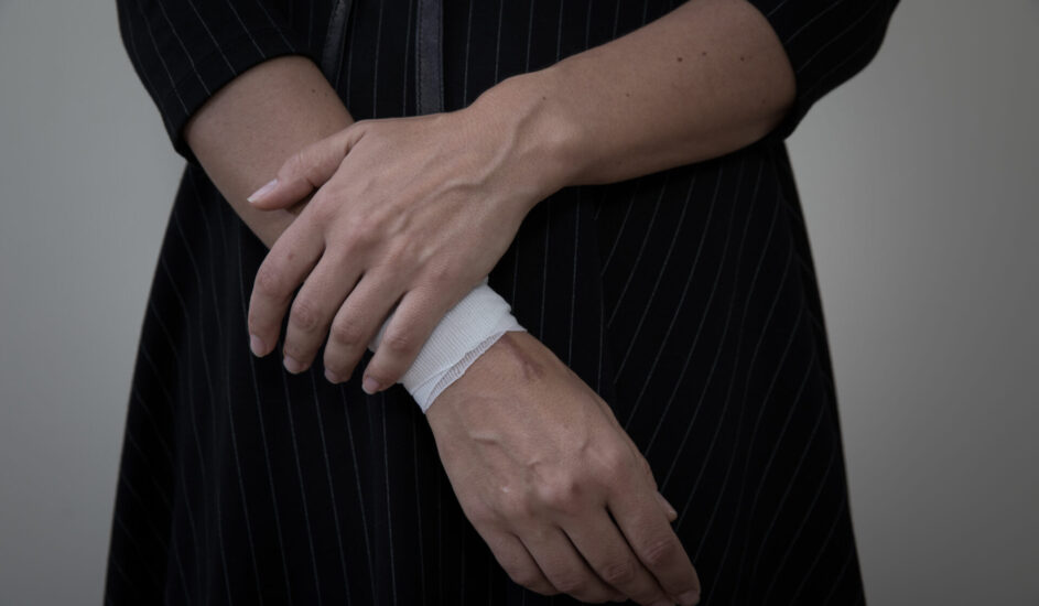 CW: self-harm. Image of a woman with a bandage on her wrist.