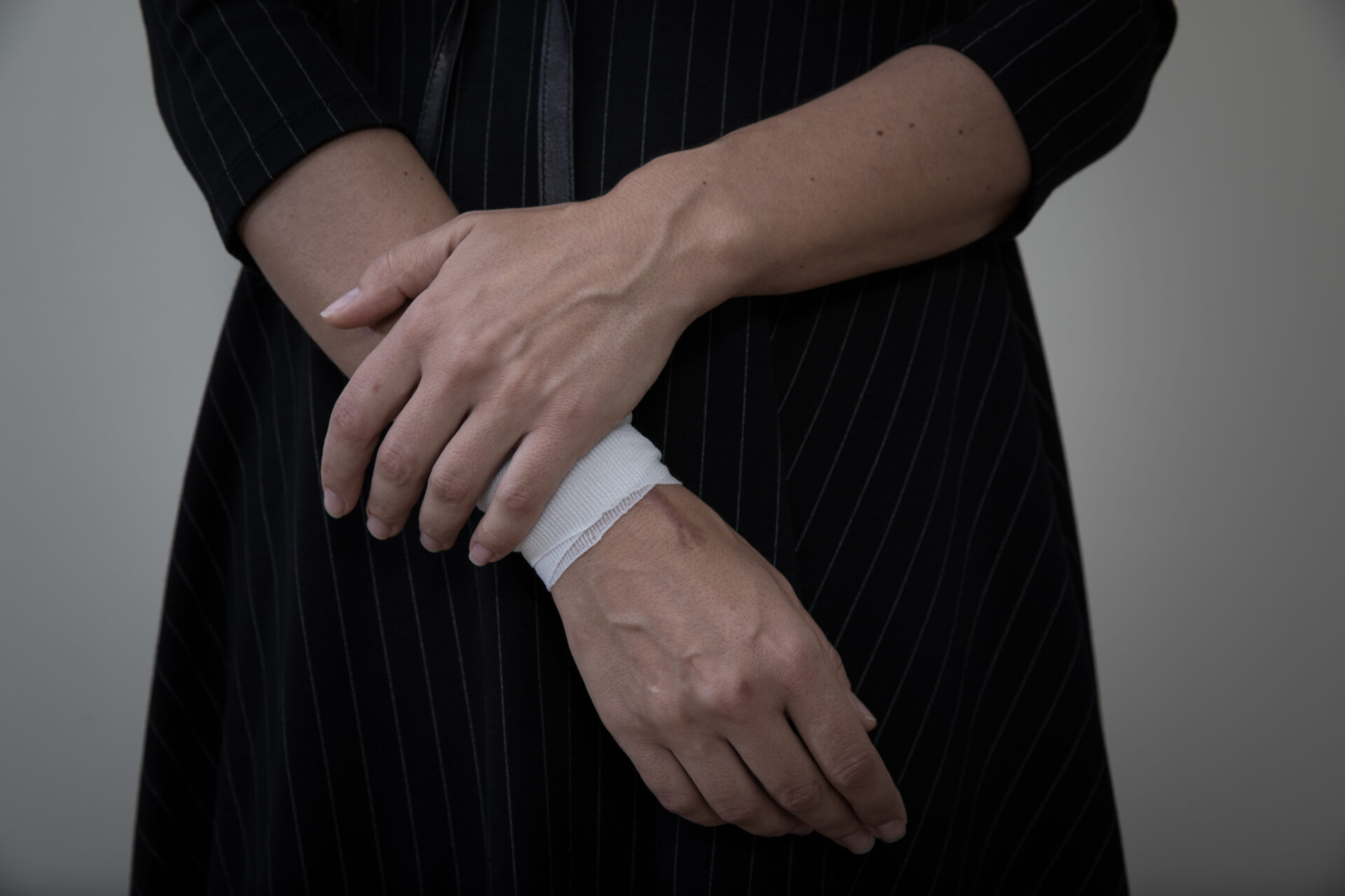 CW: self-harm. Image of a woman with a bandage on her wrist.