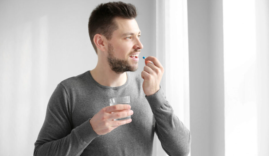 young man taking medication for mental health