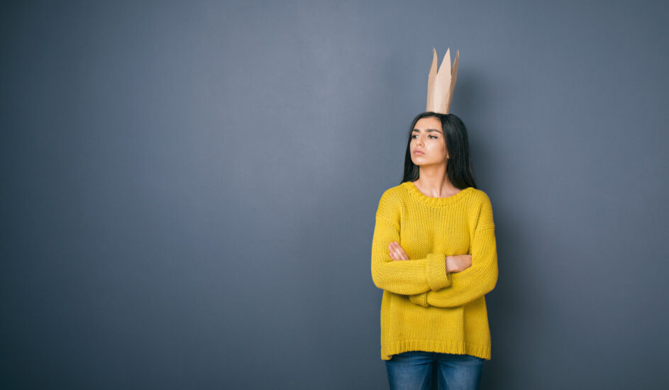 a woman wearing a paper crown, evoking an inflated sense of self often seen in people with narcissistic personality disorder