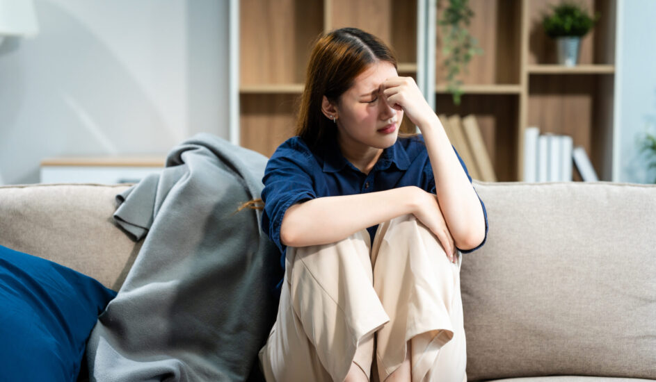 a young woman on a couch who looks upset.