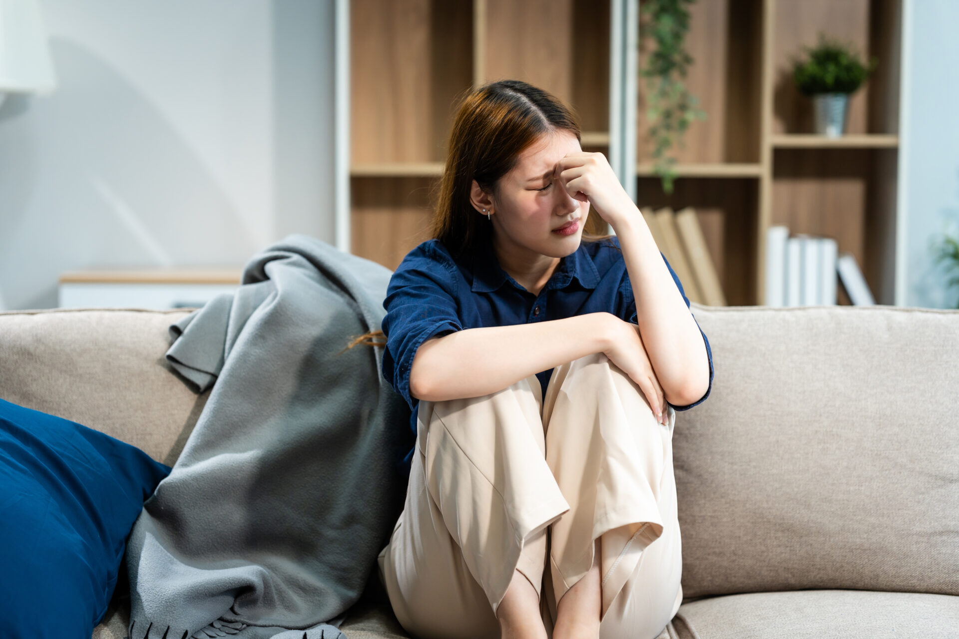 a young woman on a couch who looks upset.